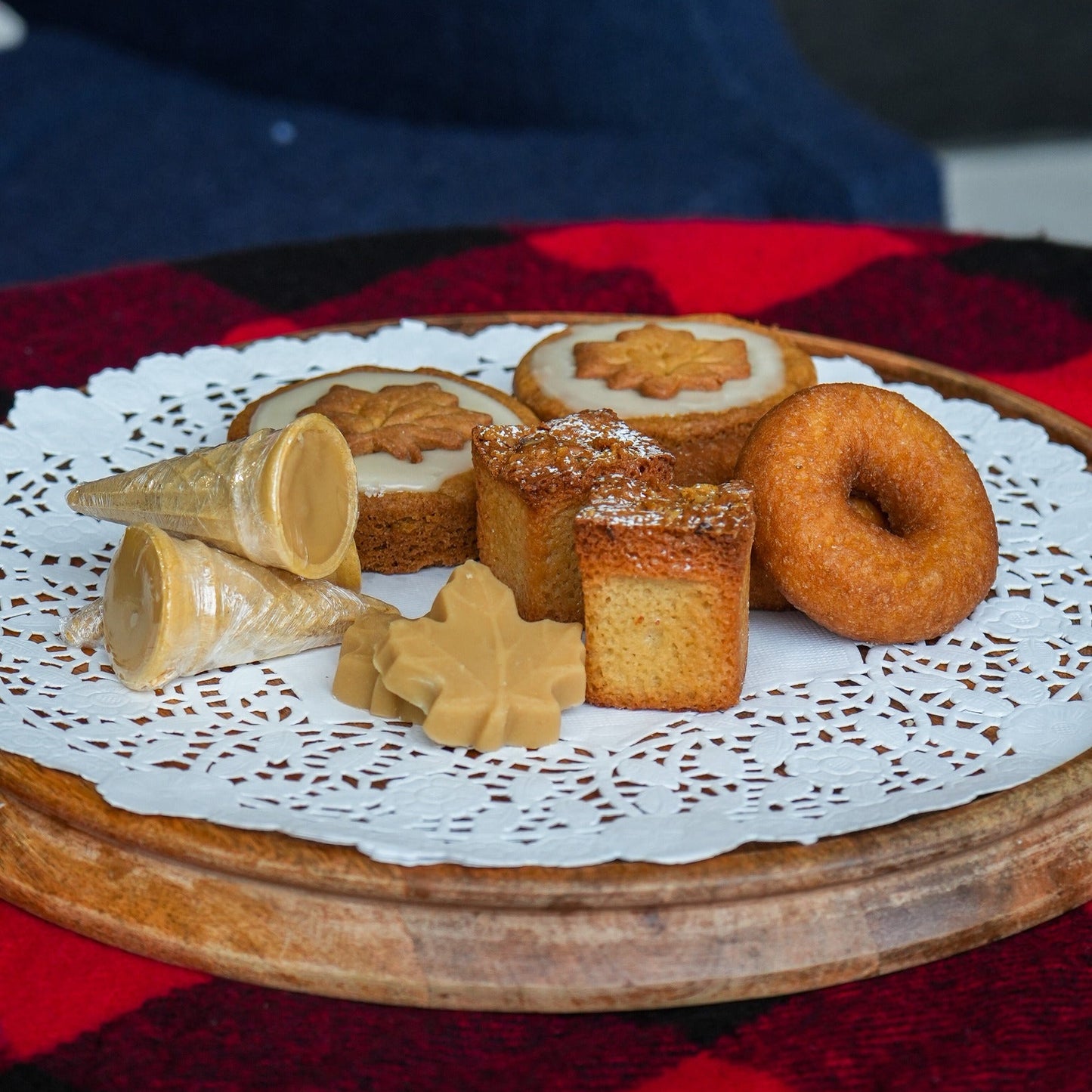 Assorted pastries on a wooden plate with a red checkered tablecloth
