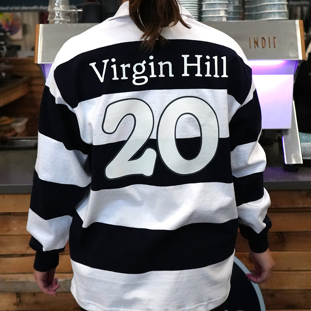 Person wearing a black and white striped shirt with 'Virgin Hill 20' text in an indoor setting.