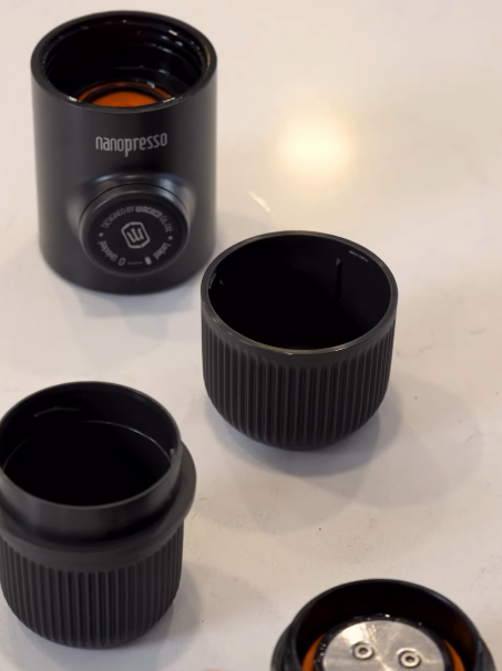 Black nanopresso coffee press components on a white surface